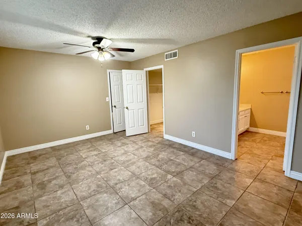 a view of a big room with wooden floor and chandelier fan