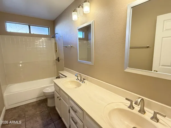 a bathroom with a granite countertop sink a toilet and bathtub