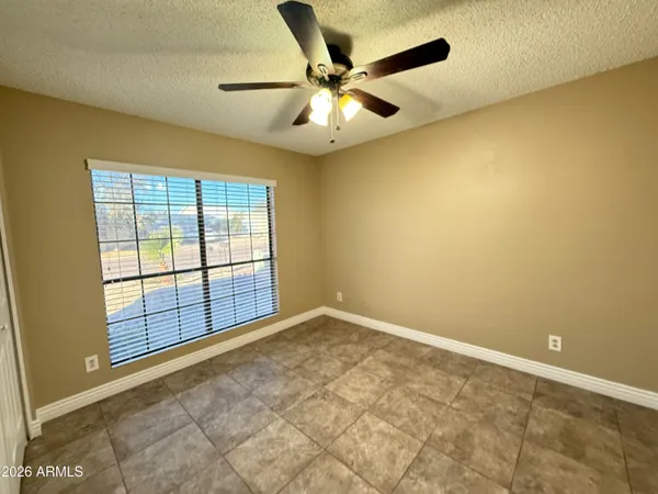 an empty room with windows and ceiling fan