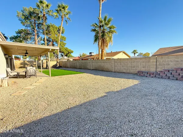 a white house with a big yard and large trees