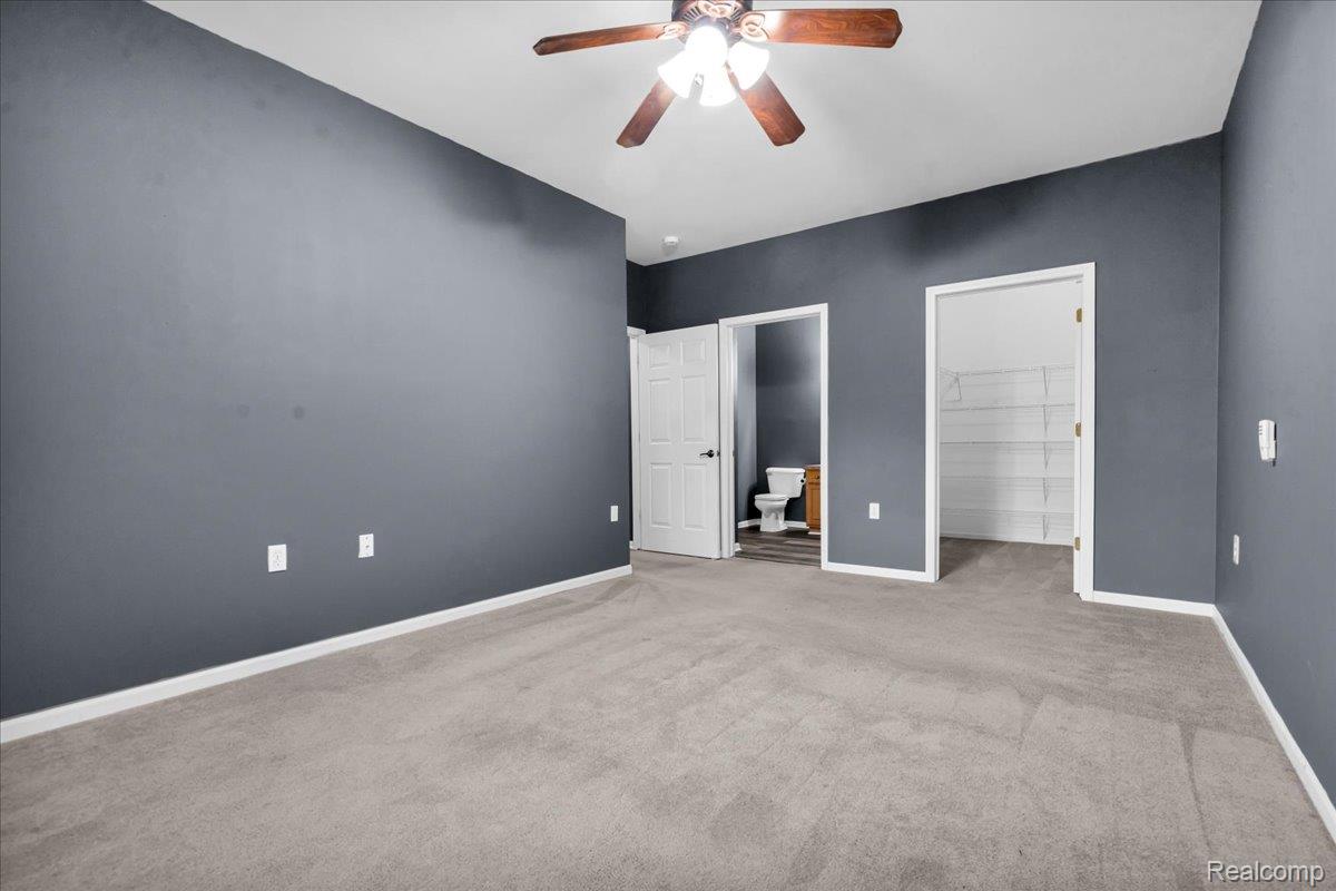 1150 Rial Lake Drive Howell, MI 48843 - Photo 16 of 24 Spacious Primary Suite with a ceiling fan, gray wall finish, light-colored carpeting, and white trim