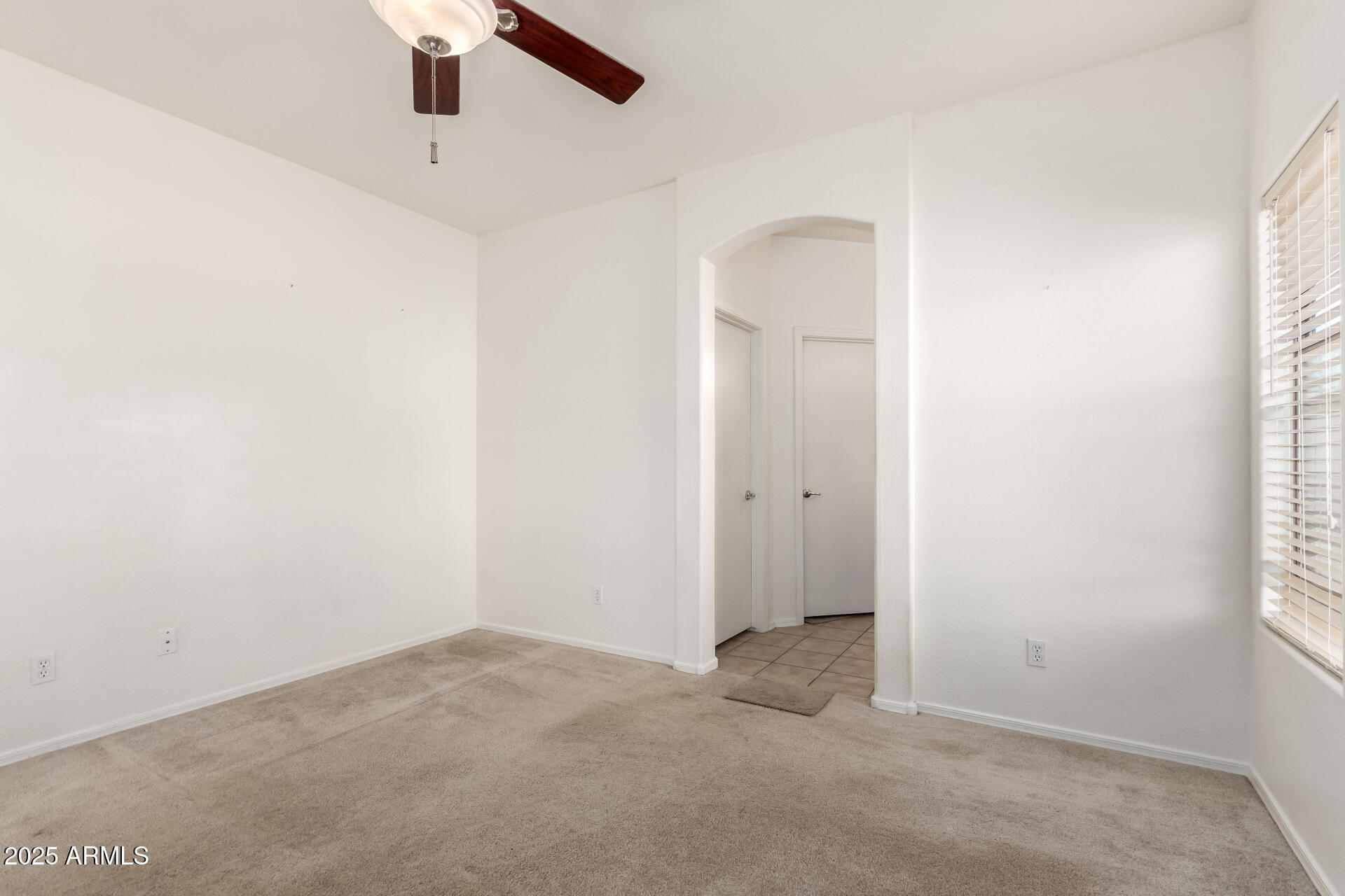 44922 Alamendras Street Maricopa, AZ 85139 - Photo 12 of 26 an empty room with a window and a ceiling fan