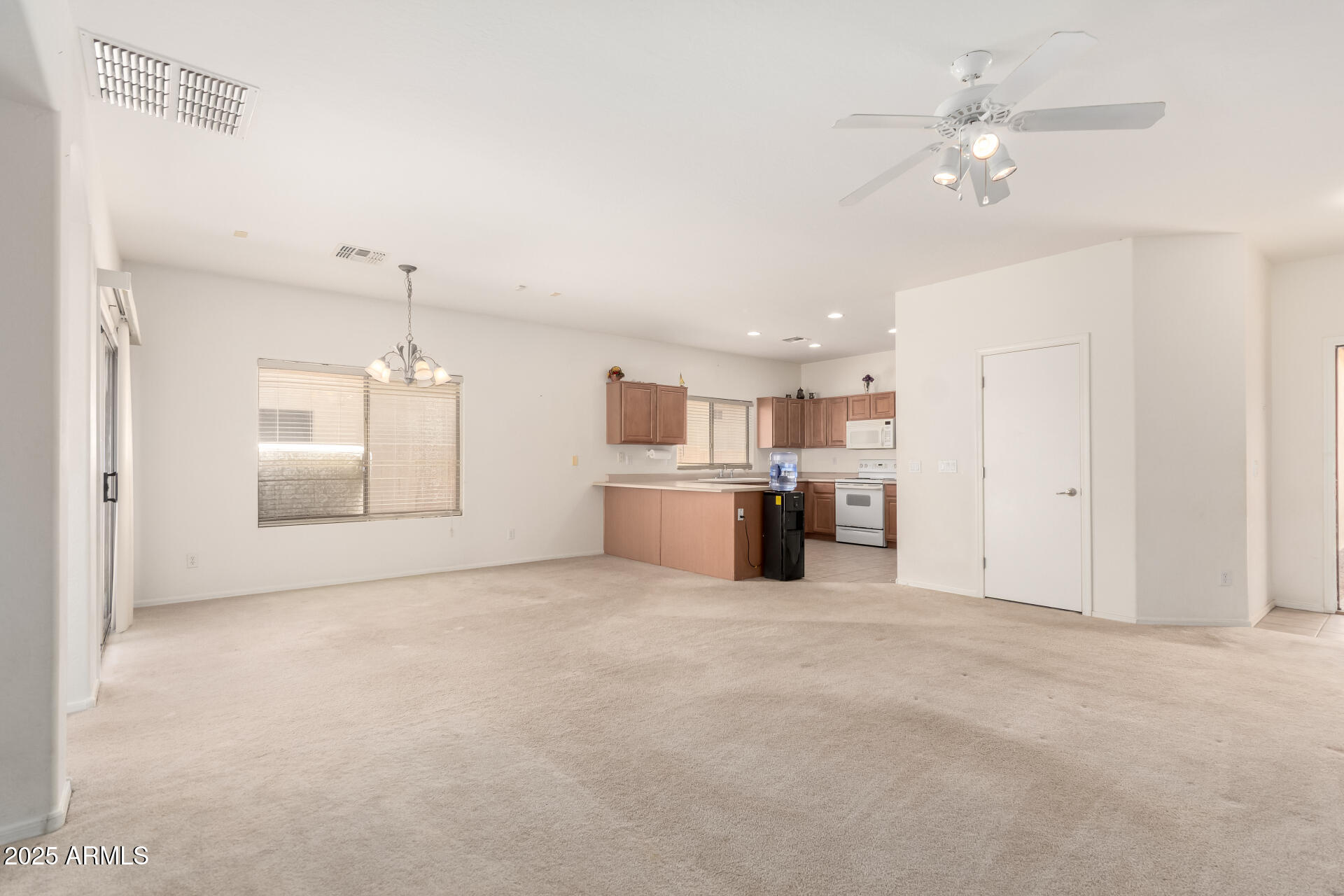 44922 Alamendras Street Maricopa, AZ 85139 - Photo 3 of 26 a view of a kitchen with furniture and a ceiling fan
