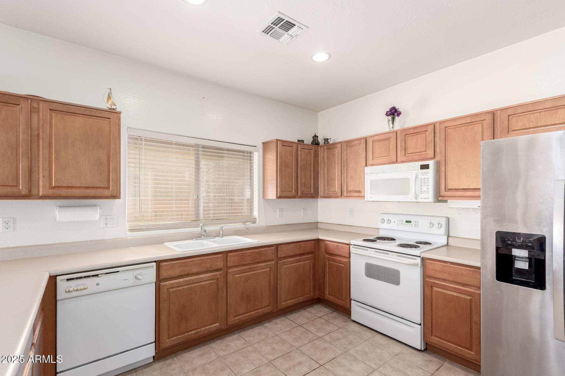 44922 Alamendras Street Maricopa, AZ 85139 - Photo 6 of 26 a kitchen with a sink white cabinets and white appliances