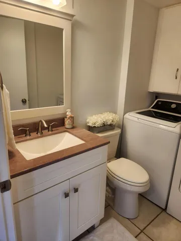 a bathroom with a granite countertop toilet sink and mirror