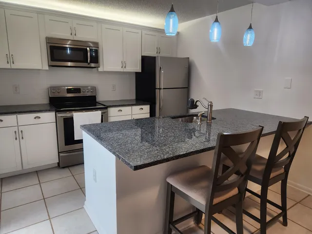 a kitchen with stainless steel appliances granite countertop a sink microwave and stove