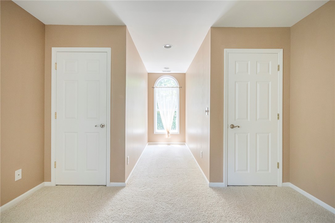 125 Inlet Pointe Drive Anderson, SC 29625 - Photo 20 of 39 A well-lit hallway with plush carpeting leads to a bright arched window.