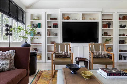 a living room with furniture and a floor to ceiling window