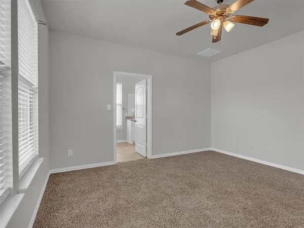 a view of an empty room and chandelier fan