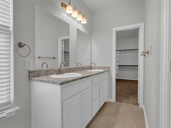 a bathroom with a granite countertop sink a light fixture and a mirror