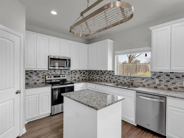 a kitchen with stainless steel appliances granite countertop a sink stove and cabinets