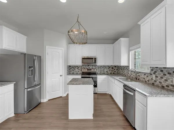 a kitchen with granite countertop stainless steel appliances a counter space and cabinets