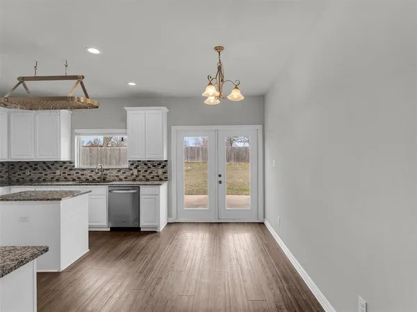wooden floor in an empty room with a kitchen