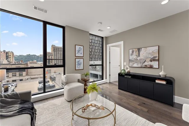 a living room with furniture a large window and kitchen view