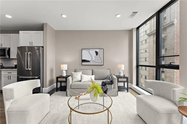 a living room with furniture a dining table and a potted plant