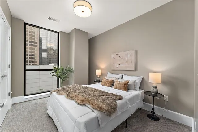 a bedroom with a bed and a lamp on the dresser