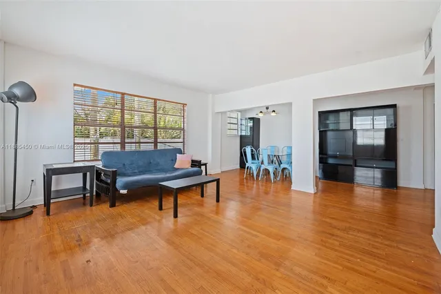 a living room with furniture and a table with wooden floor