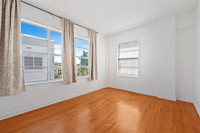 a big room with wooden floor and a bathroom