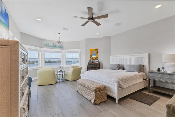 a bedroom with a bed lamp on desk and a window