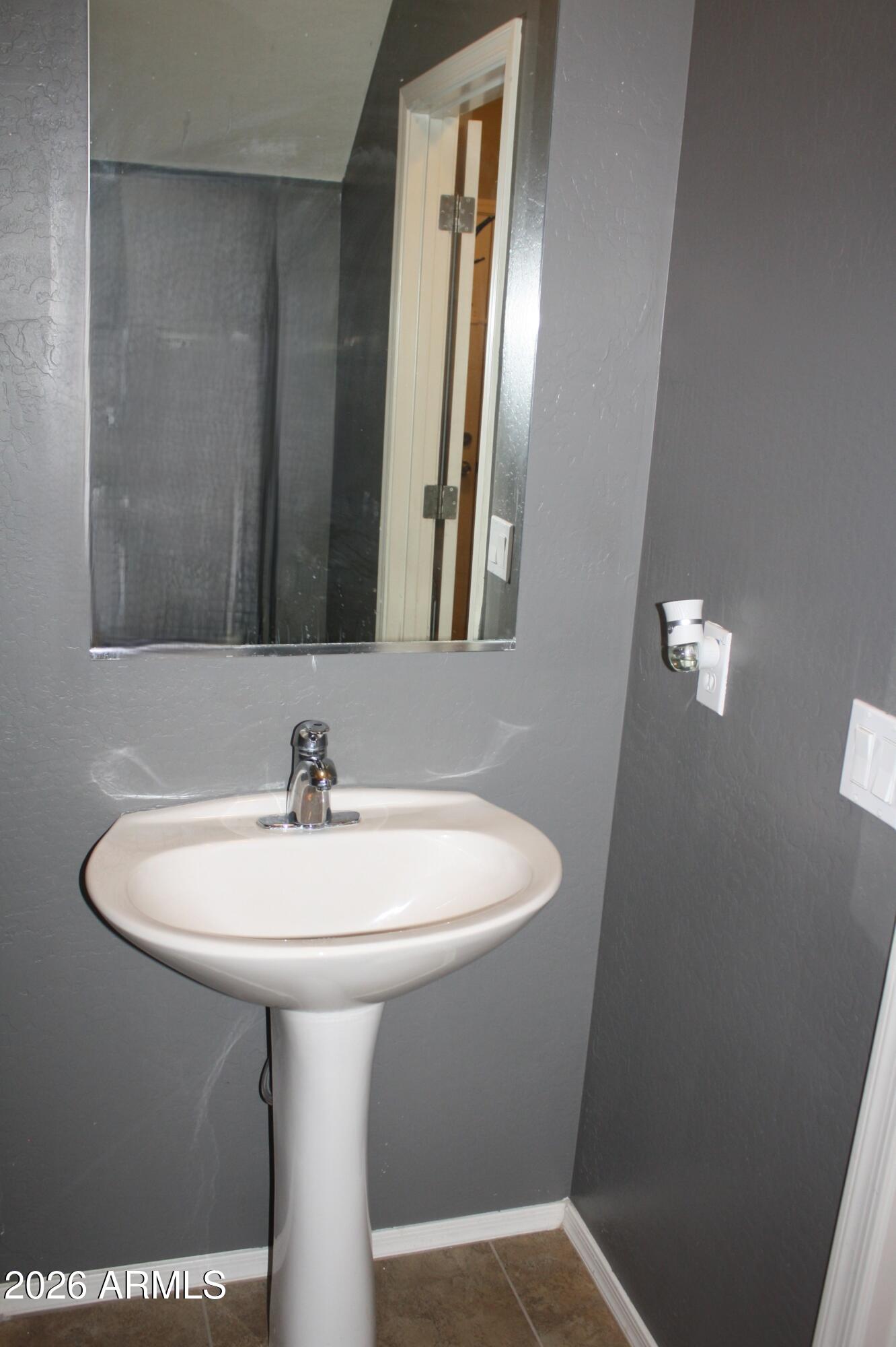 10225 West Camelback Road, Unit 19 Phoenix, AZ 85037 - Photo 18 of 51 a bathroom with a sink a mirror and vanity