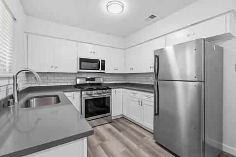 a kitchen with a refrigerator sink and stove