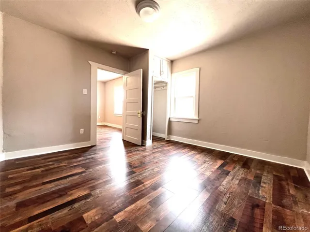 a view of empty room with wooden floor
