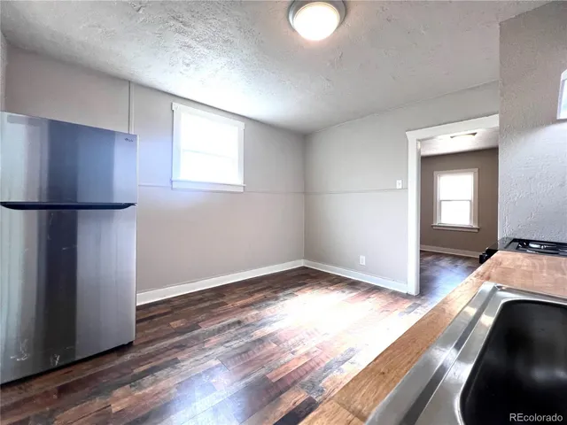 a kitchen with a refrigerator and a stove top oven
