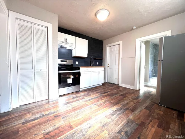 a kitchen with granite countertop a sink cabinets and stainless steel appliances