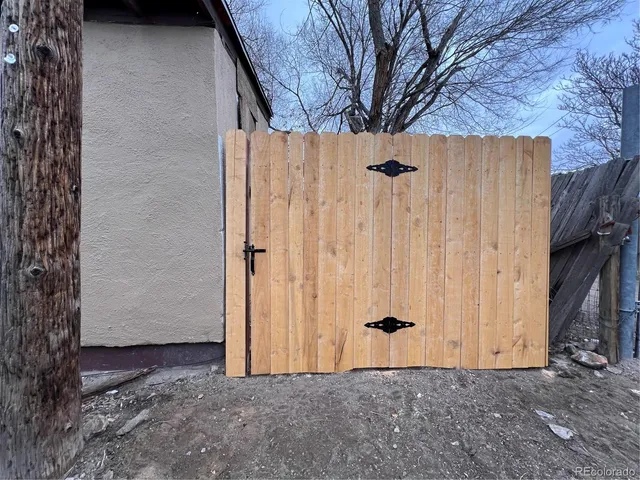 a view of a backyard with barn and wooden fence