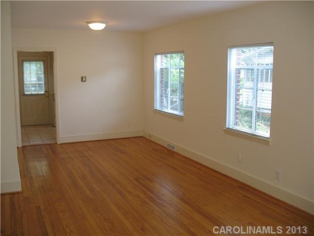 1634 Club Road Charlotte, NC 28205 - Photo 4 of 8 an empty room with wooden floor and windows