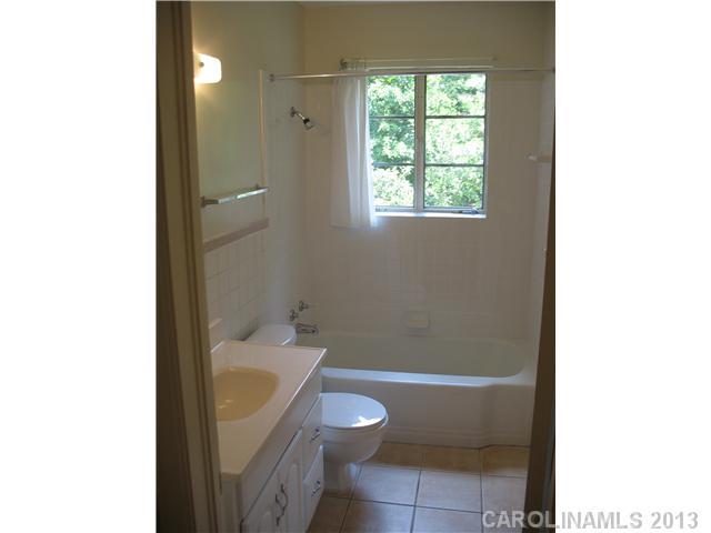 1634 Club Road Charlotte, NC 28205 - Photo 7 of 8 a bathroom with a granite countertop toilet a sink and bathtub
