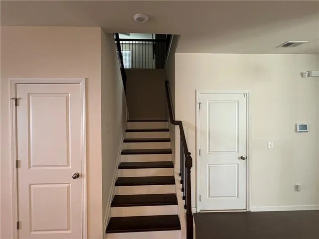 a view of a hallway with wooden floor and staircase