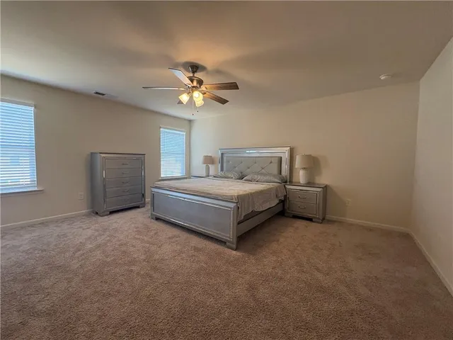 a white bed sitting in a bedroom and chandelier