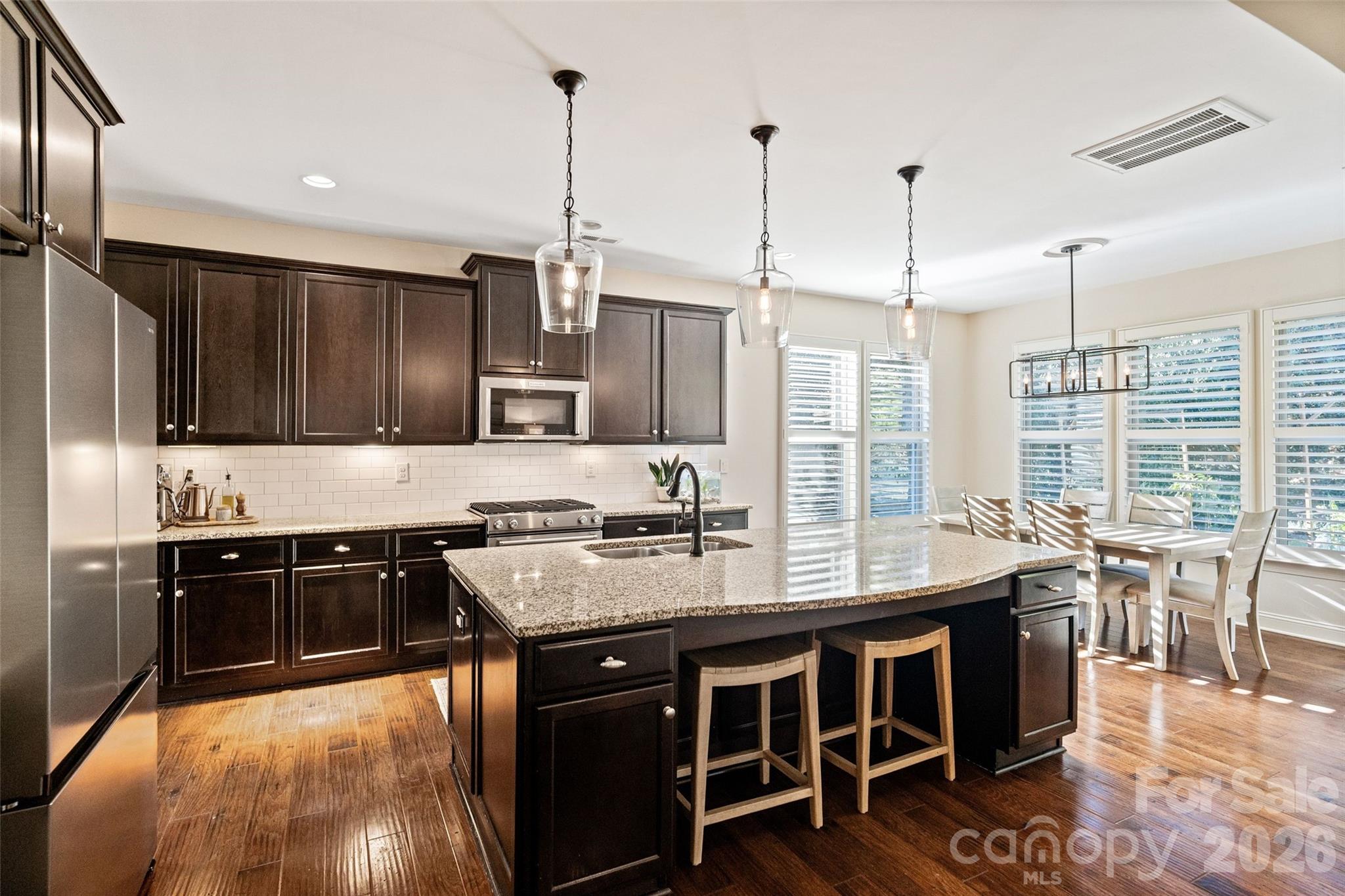 9104 Blue Ridge Drive Indian Land, SC 29707 - Photo 11 of 41 a kitchen with stainless steel appliances granite countertop a stove a sink and a wooden floors