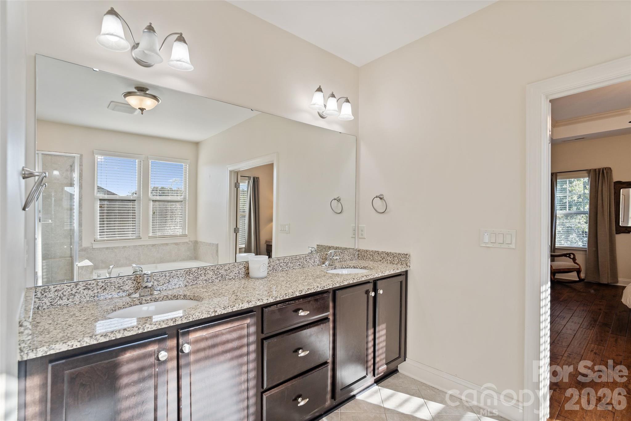 9104 Blue Ridge Drive Indian Land, SC 29707 - Photo 22 of 41 a bathroom with a granite countertop sink a large mirror and shower