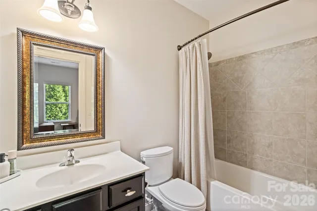 a bathroom with a granite countertop sink a toilet and shower