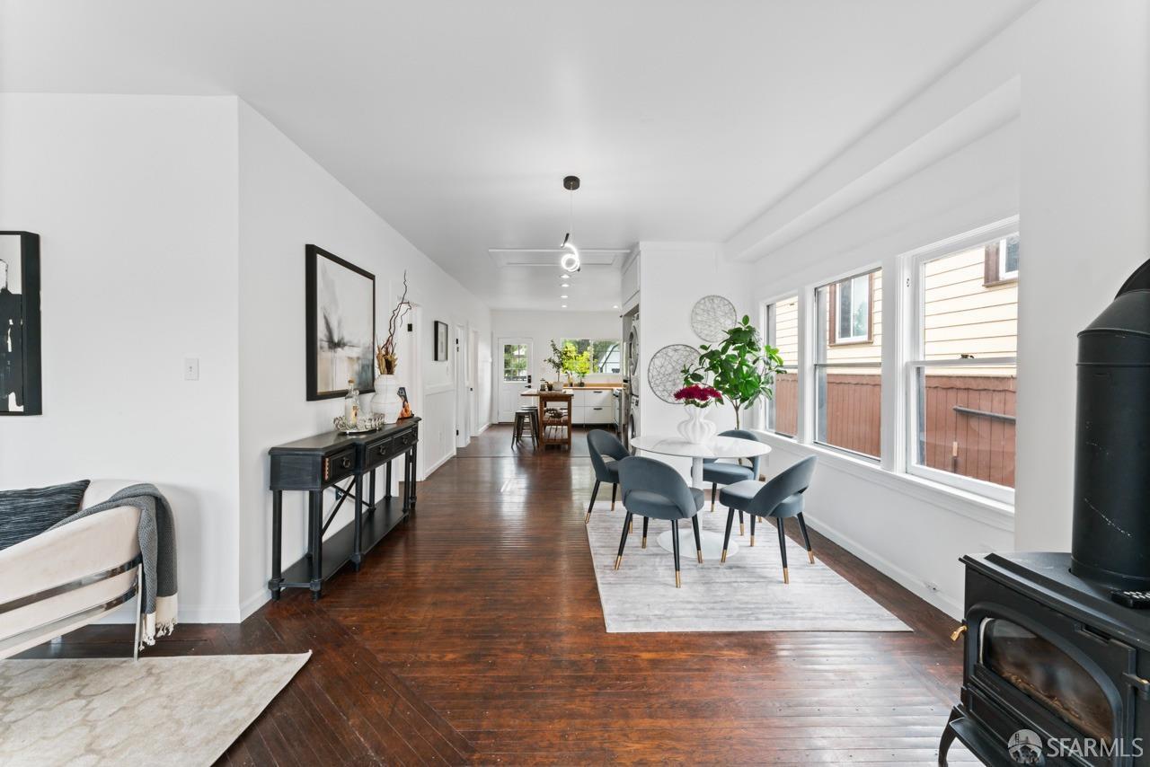 1718 37th Avenue Oakland, CA 94601 - Photo 11 of 33 a living room with furniture a dining table and a flat screen tv with wooden floor