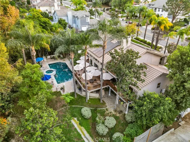 an aerial view of residential house with outdoor space and trees all around