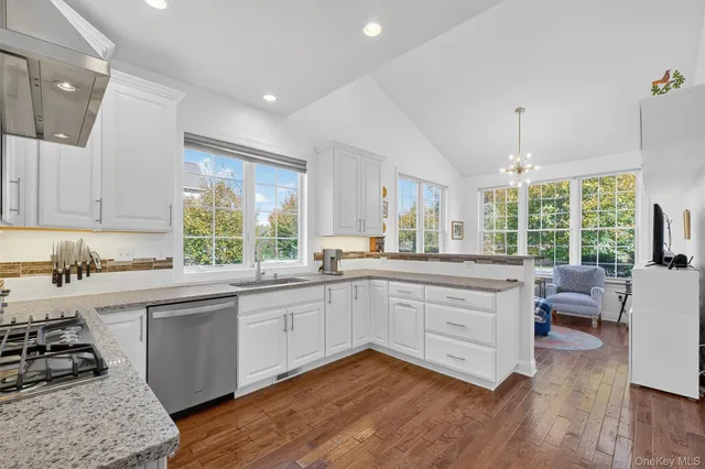 a kitchen with stainless steel appliances granite countertop wooden floors and white cabinets