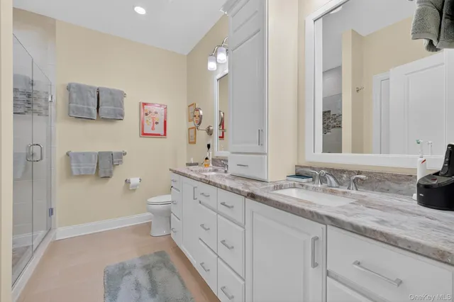 a bathroom with a granite countertop sink mirror vanity and toilet