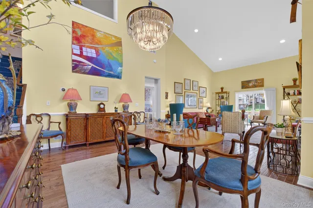 a view of a dining room with furniture a chandelier and wooden floor