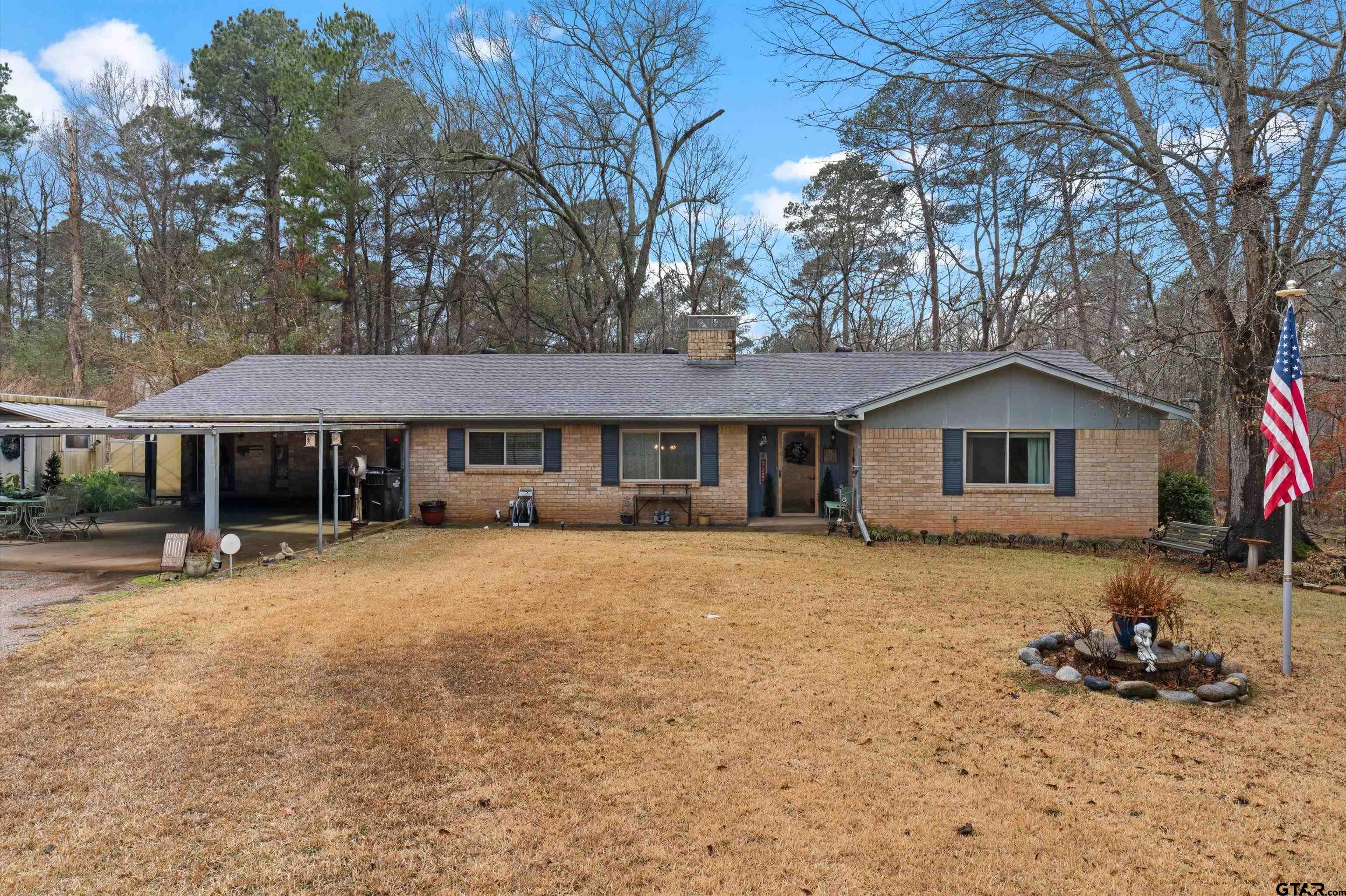 a front view of a house with a yard and trees