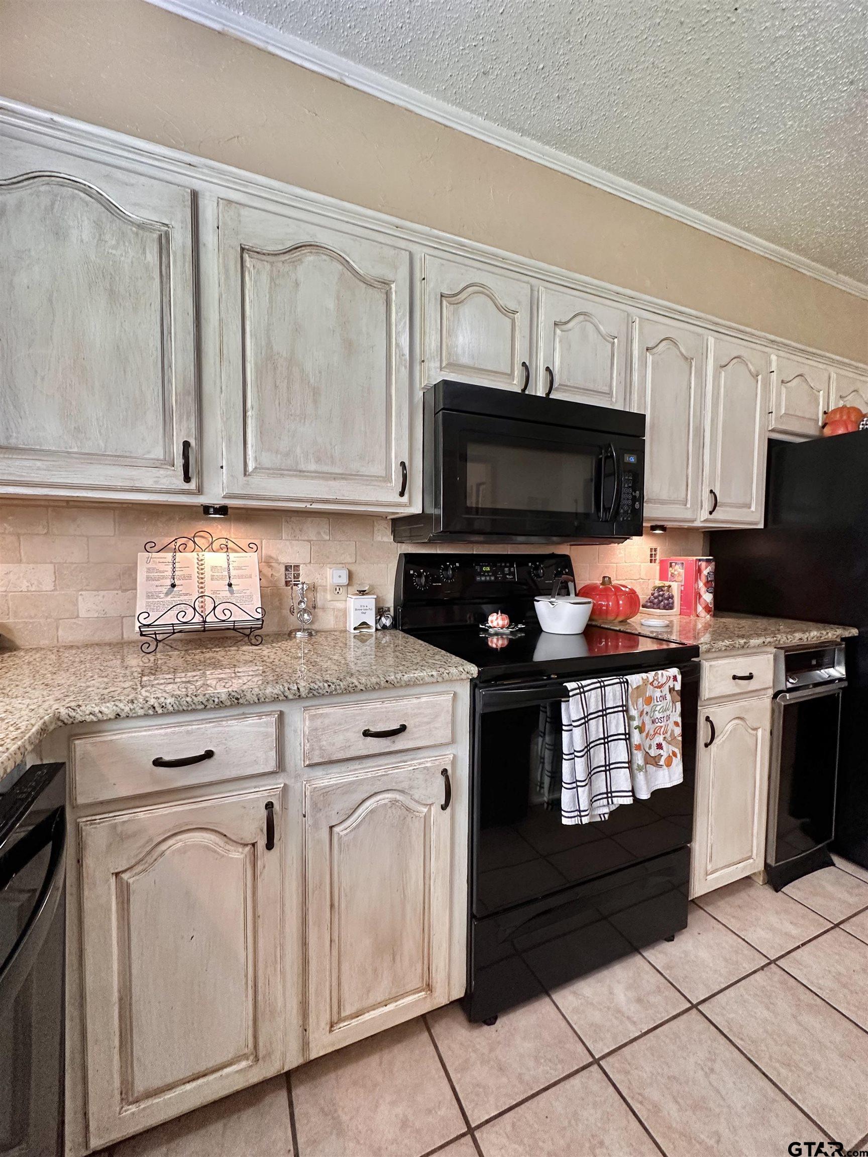 3501 Boyd Road Longview, TX 75604 - Photo 13 of 40 a kitchen with granite countertop a stove top oven microwave and cabinets