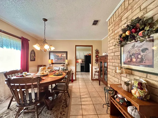 a view of a dining room and livingroom with furniture wooden floor a chandelier