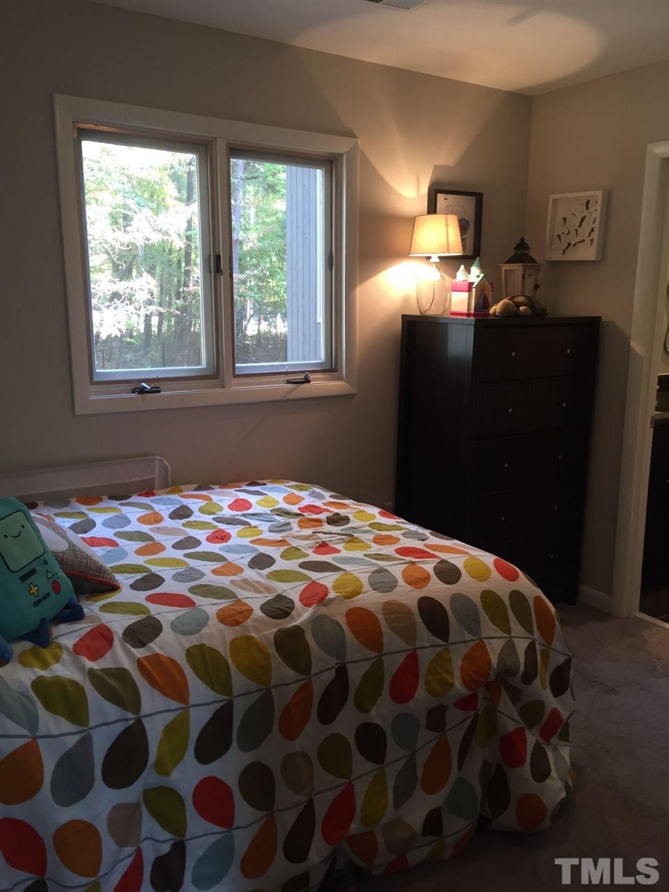 5400 Sylvan Lane Raleigh, NC 27613 - Photo 16 of 24 a bedroom with a bed and a lamp next to a window