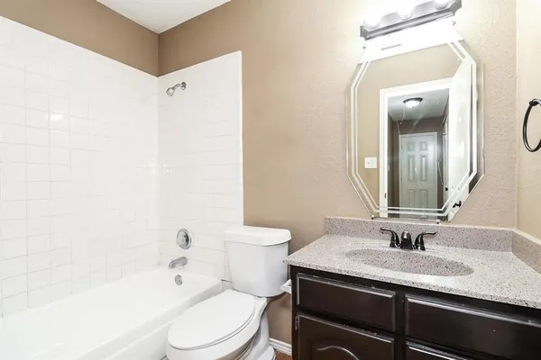 a bathroom with a granite countertop sink toilet and shower