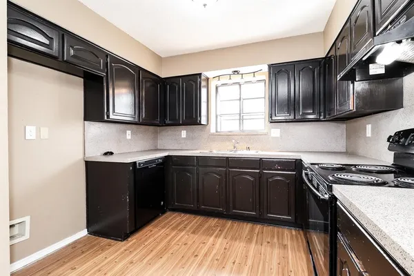 a kitchen with granite countertop cabinets stainless steel appliances a sink and a window