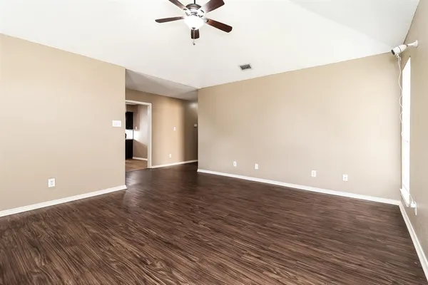 a view of an empty room with wooden floor