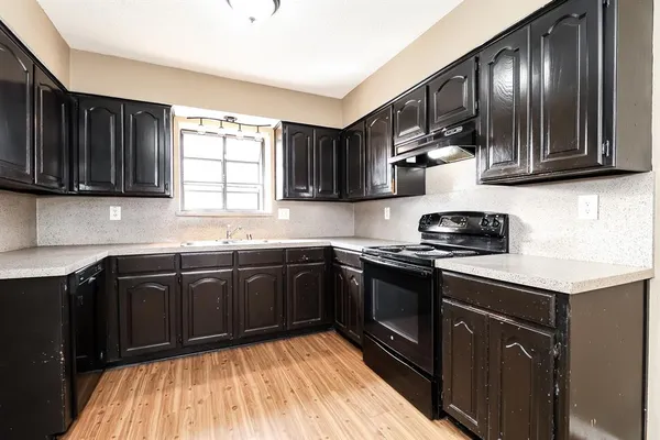 a kitchen with stainless steel appliances granite countertop wooden cabinets a stove top oven a sink and dishwasher
