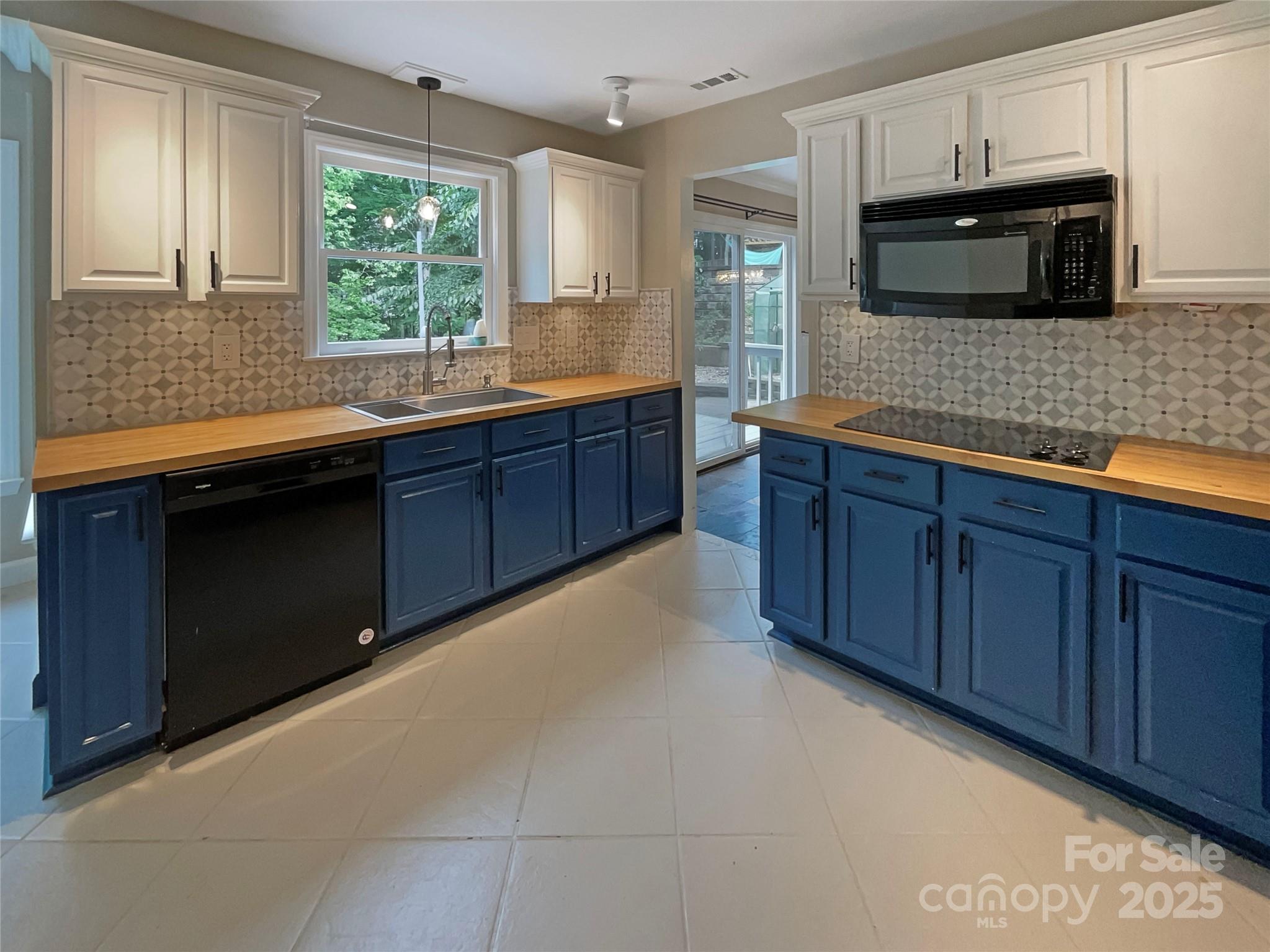 12092 Spinnaker Drive Fort Mill, SC 29708 - Photo 6 of 20 a kitchen with stainless steel appliances granite countertop wooden cabinets a stove a sink and a microwave